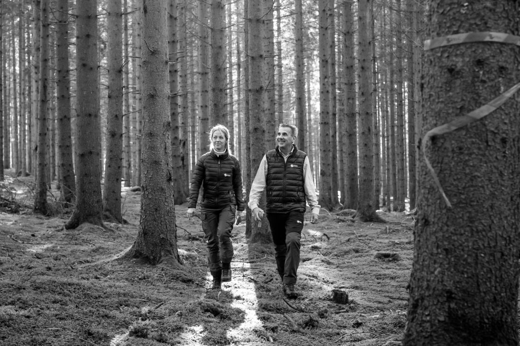 En man och en kvinna promenerar i skogen